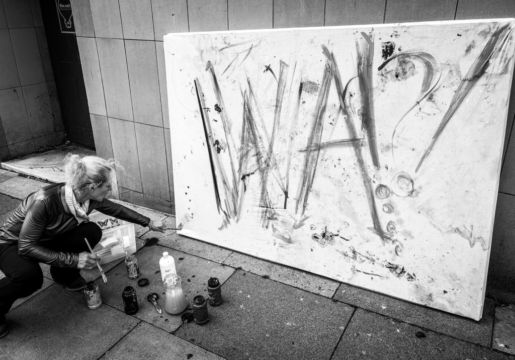 Artist painting WA on large canvas outside