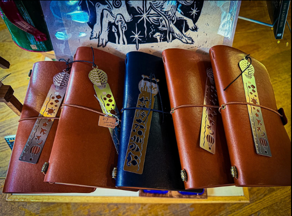 Photo of 5 leather-bound journals with silver coloured bookmarks